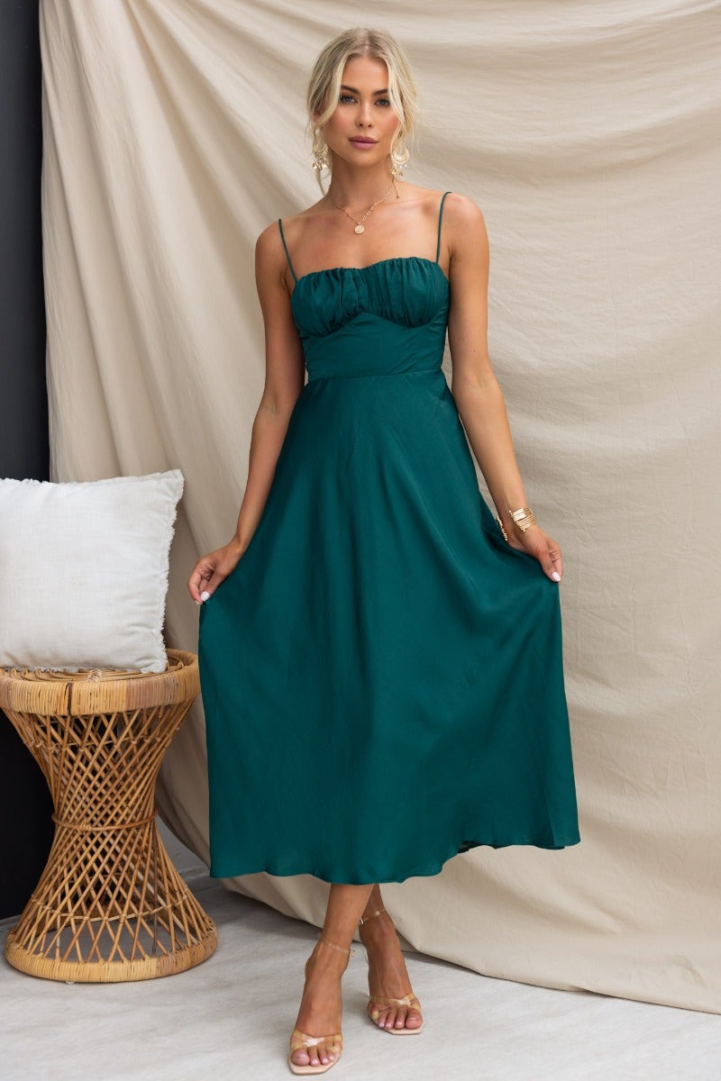 Allion Midi Dress in green with adjustable straps, gathered bust, and tie detail at the back, shown on a model.