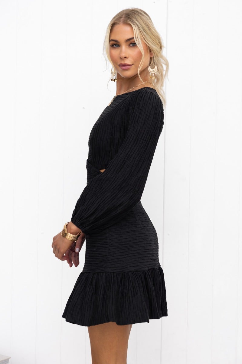 Tovia Dress in black textured material featuring a round neckline, cut-out waist, and puffed sleeves.