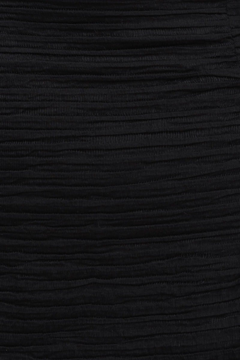 Close-up of black textured fabric of Tovia dress, featuring a layered design and sophisticated appearance.