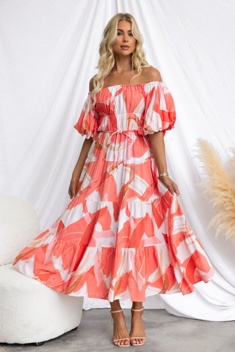 Model wearing a multi-colour print Quetta midi dress with an elastic neckline and puff sleeves.