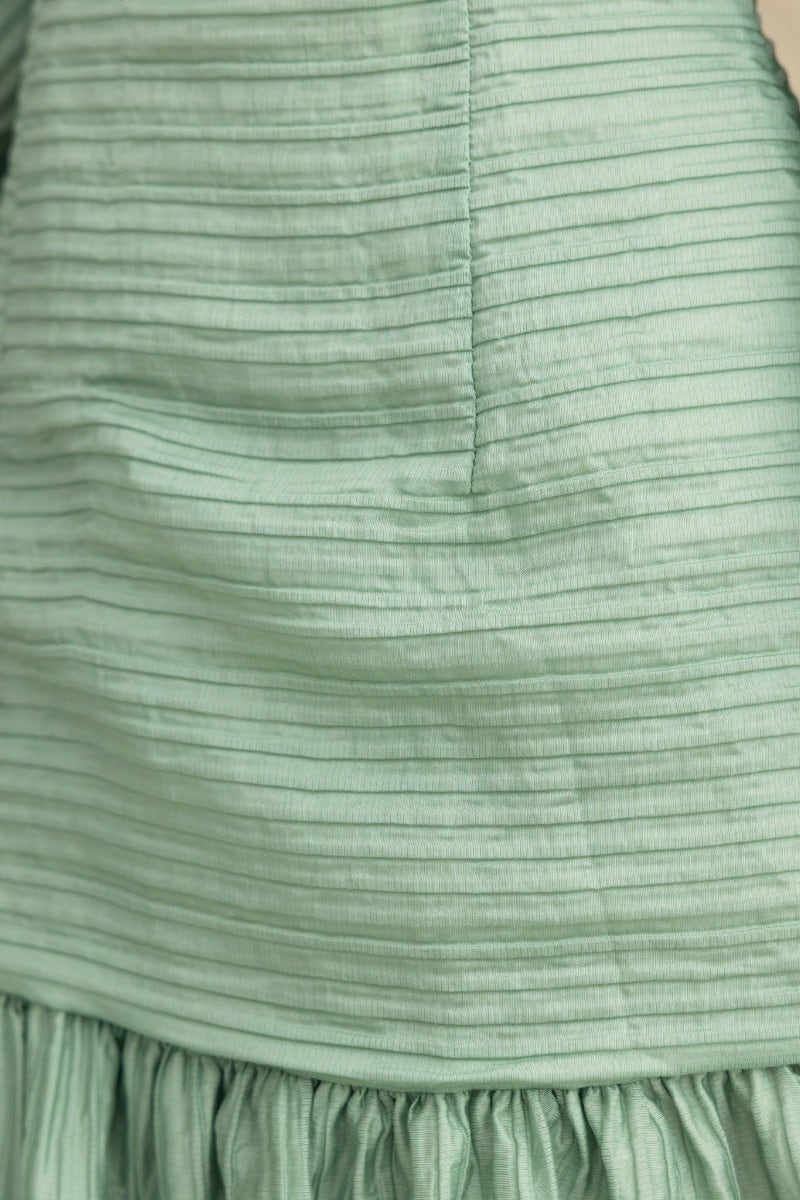 Close-up of textured mint green fabric with vertical stripes, part of the Tovia Dress.