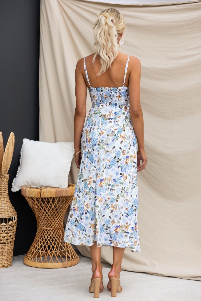 Back view of a floral fawn midi dress with adjustable straps, showcasing twist detail and elastic back, styled for summer.
