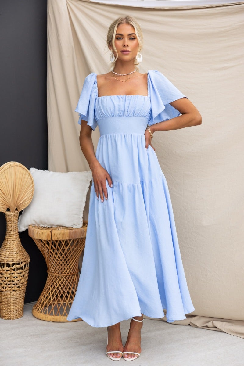Light blue Hanni Maxi Dress featuring elastic sleeves, tie detail at back, and lined design perfect for summer occasions.