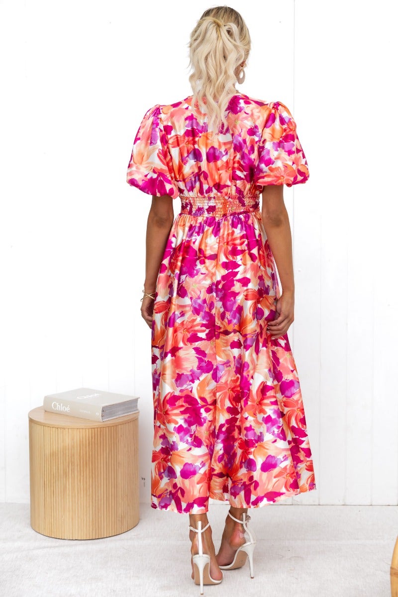 Back view of the Blazing Maxi Dress, showcasing a floral print and puff sleeves in vibrant pink hues.