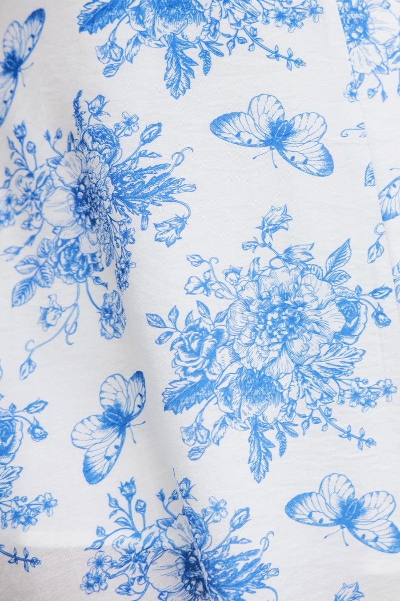 Floral print pattern featuring blue flowers and butterflies on a white fabric background, perfect for Briony Maxi Dress.