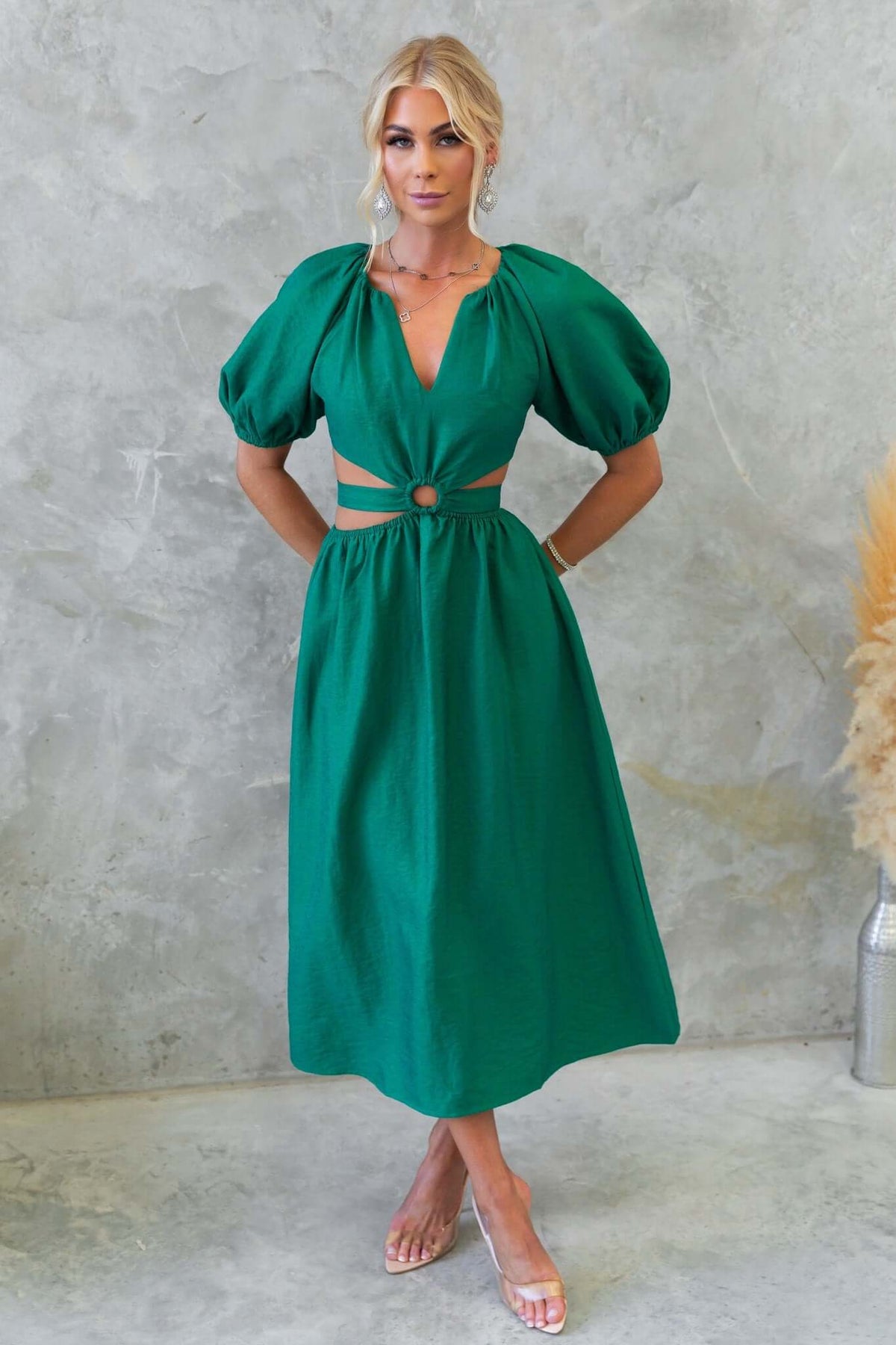 Isabelline midi dress in vibrant green with puff sleeves, V-neck, waist cut-out, and fabric tie detail.