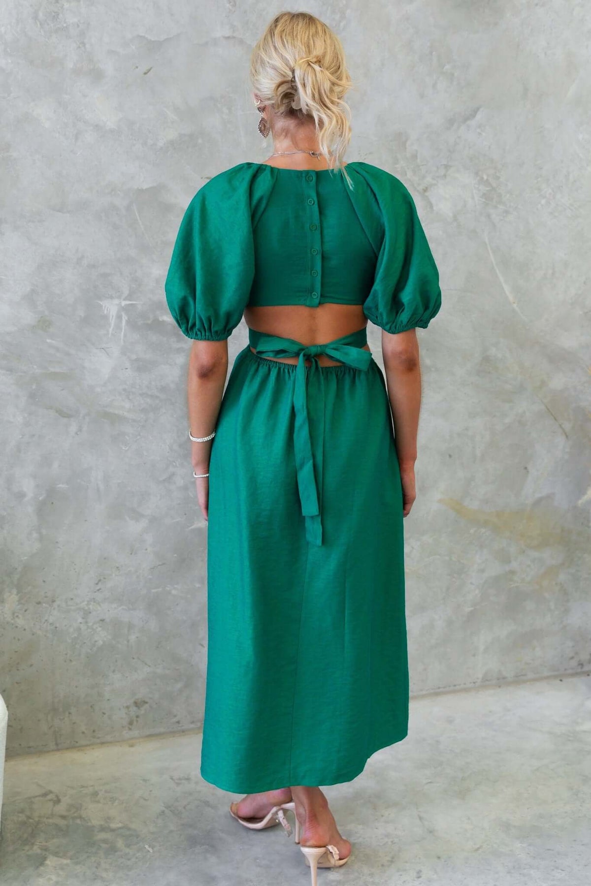 Back view of Isabelline midi dress featuring puff sleeves and waist cut-out with a fabric tie detail.