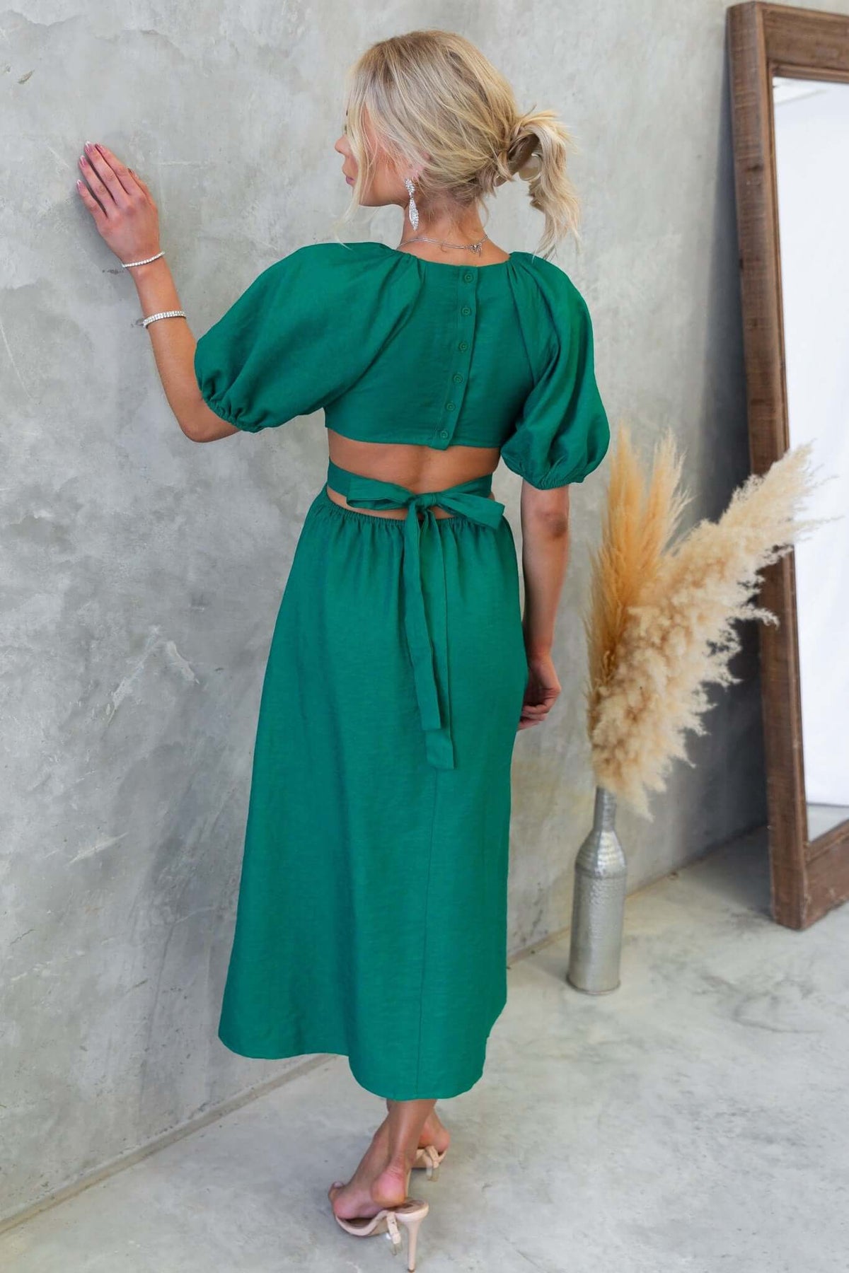 Elegant green Isabelline Midi Dress with puff sleeves and cut-out waist, styled nicely with back buttons and a fabric tie.