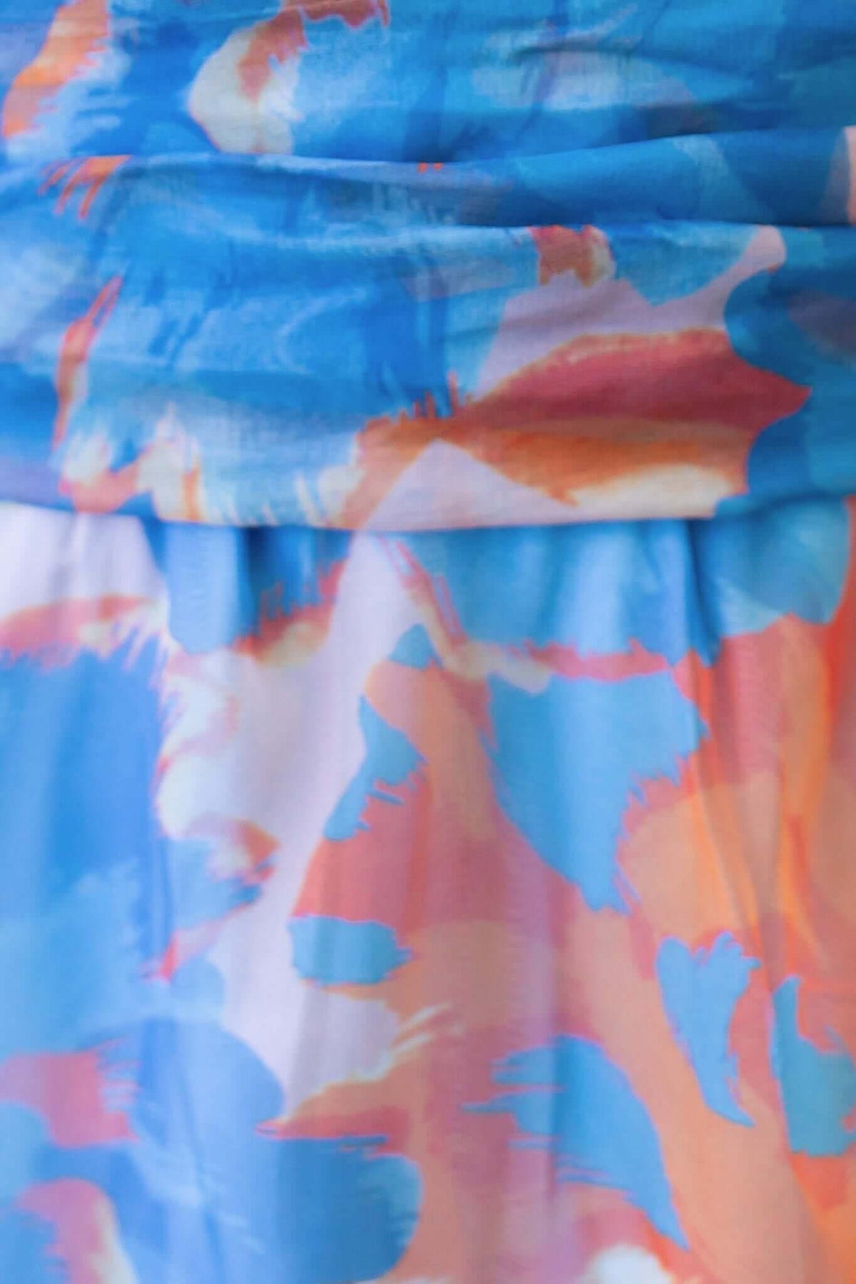 Close-up of colorful fabric featuring blue and orange abstract patterns, showcasing the Ivrea Midi Dress.