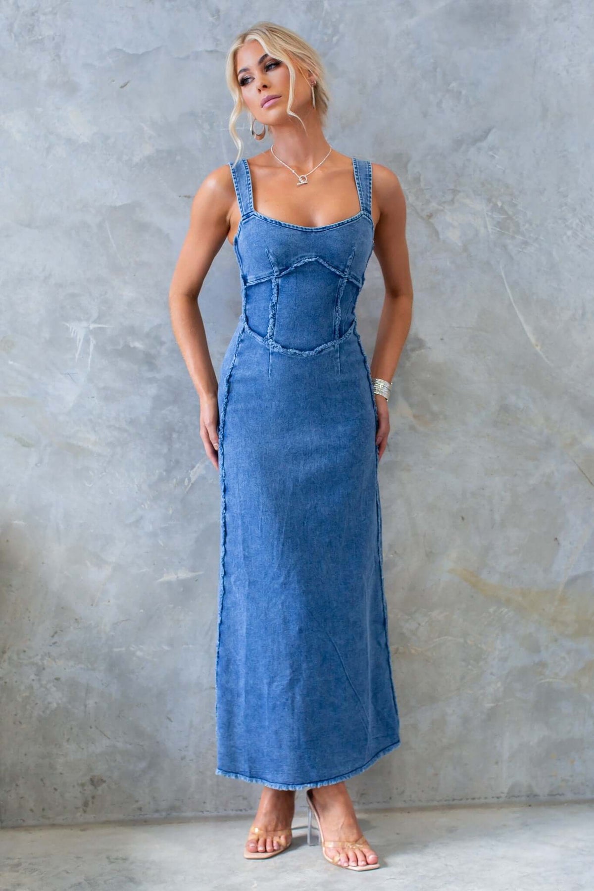 Model wearing a Heads Turn Denim Maxi Dress with adjustable straps and a back split, showcasing a stylish denim design.