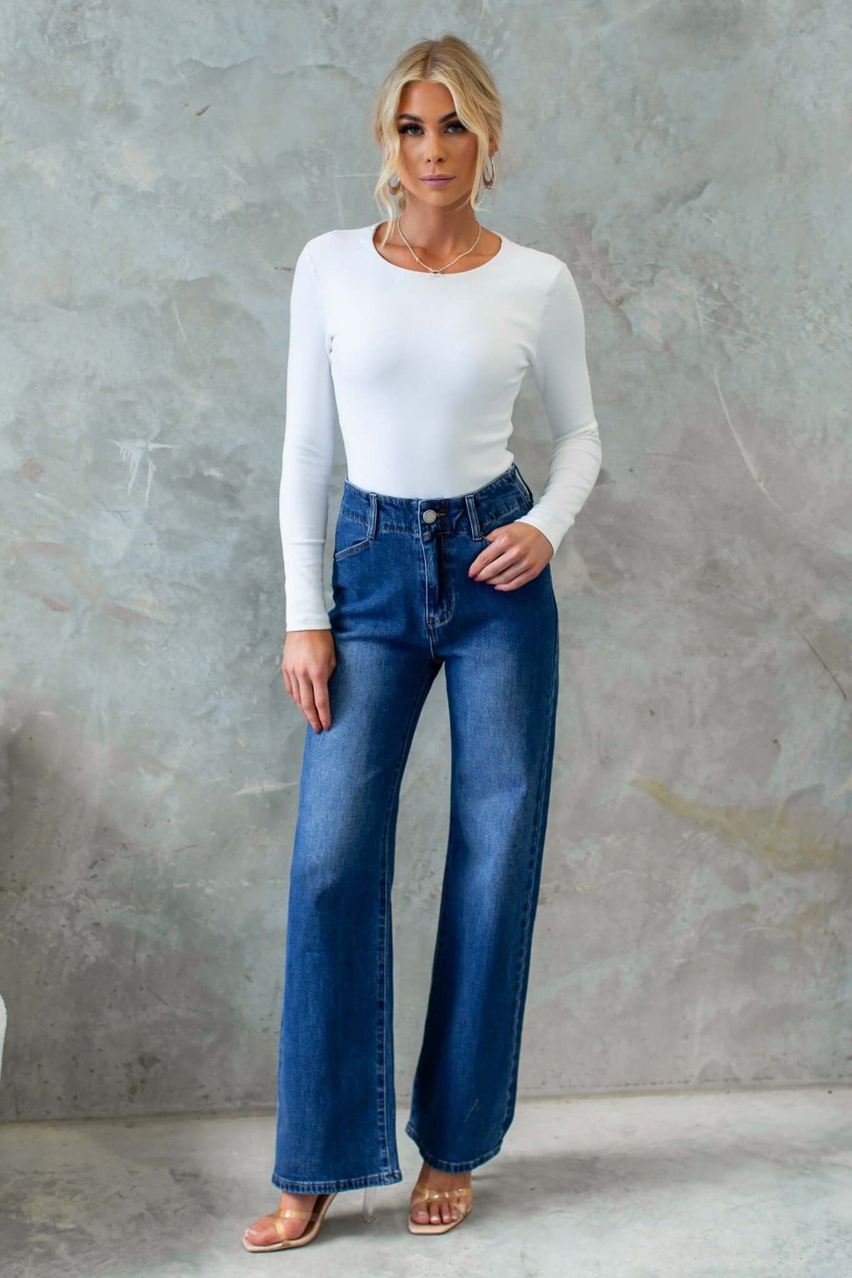 Model wearing Wallen Jeans, mid-high waist denim with wide legs, paired with a fitted white long-sleeve top.