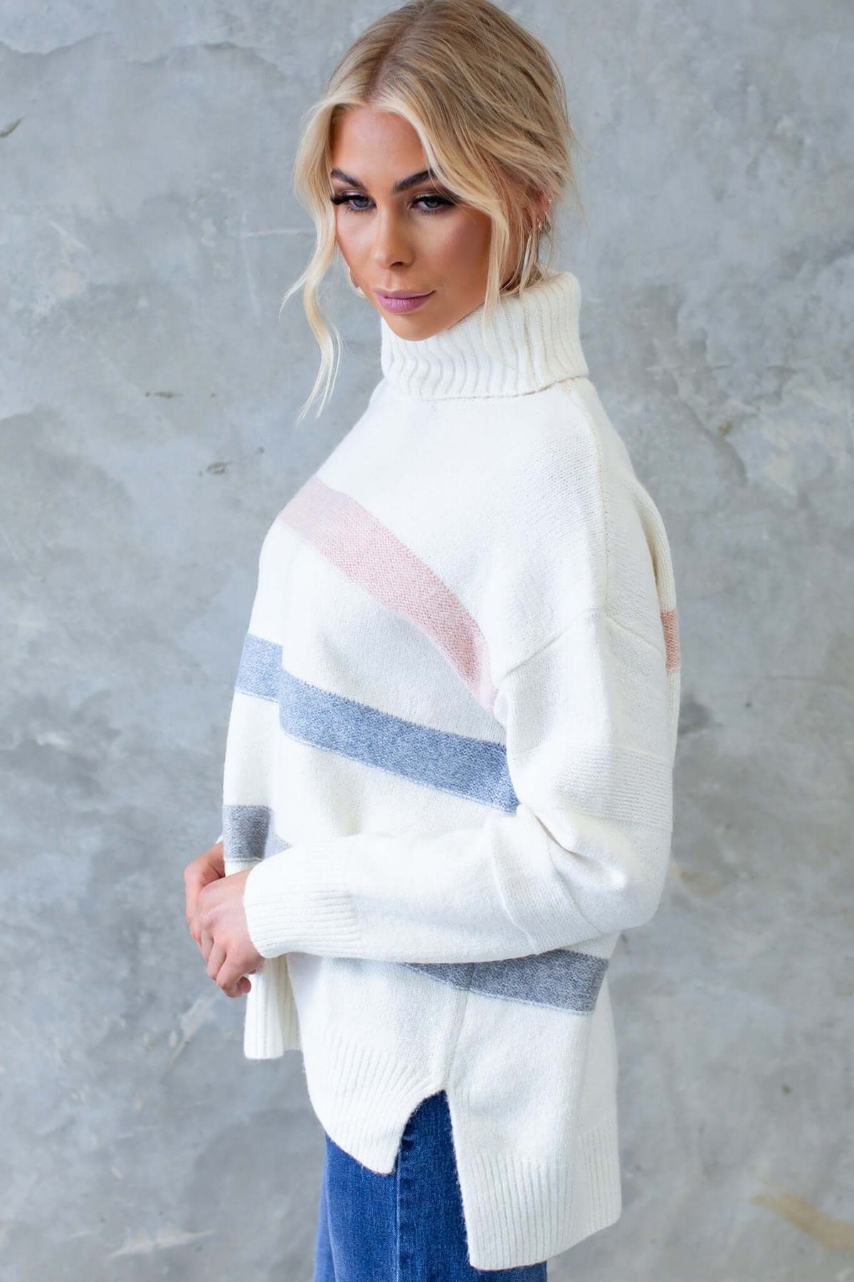 White Lovey Jumper with turtle neckline and side splits, featuring pastel stripes, perfect for a cozy look.