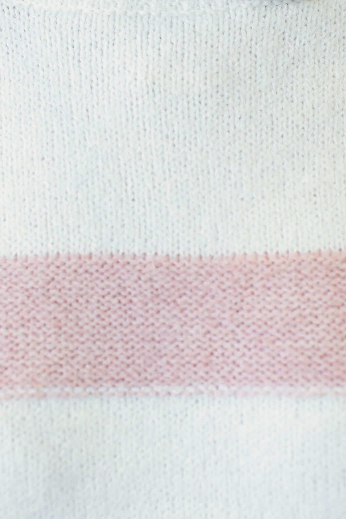 Close-up of soft knit fabric with a pink stripe, perfect for the Lovey Jumper with turtle neckline and side splits.