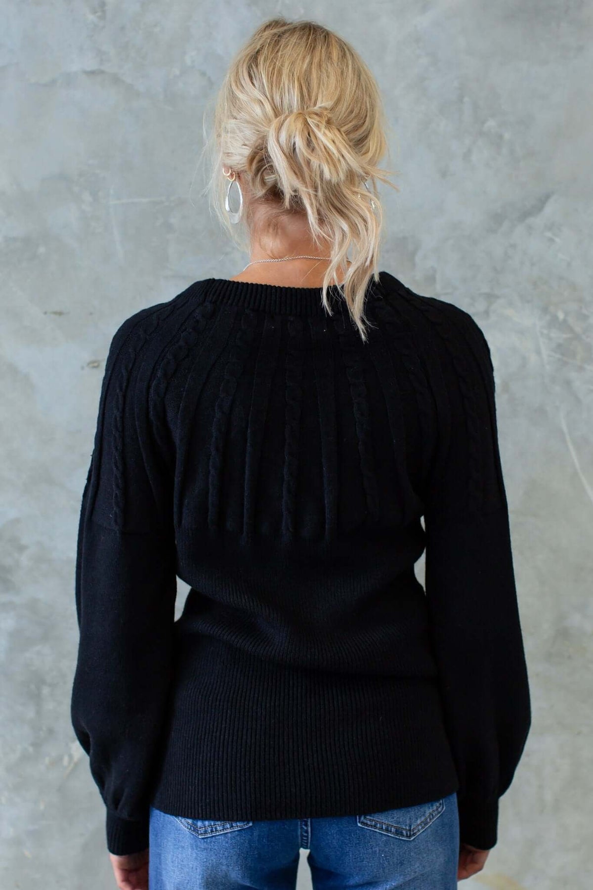 Back view of black Alma Jumper featuring cable knit design and slightly relaxed fit. Perfect for stylish fall outfits.