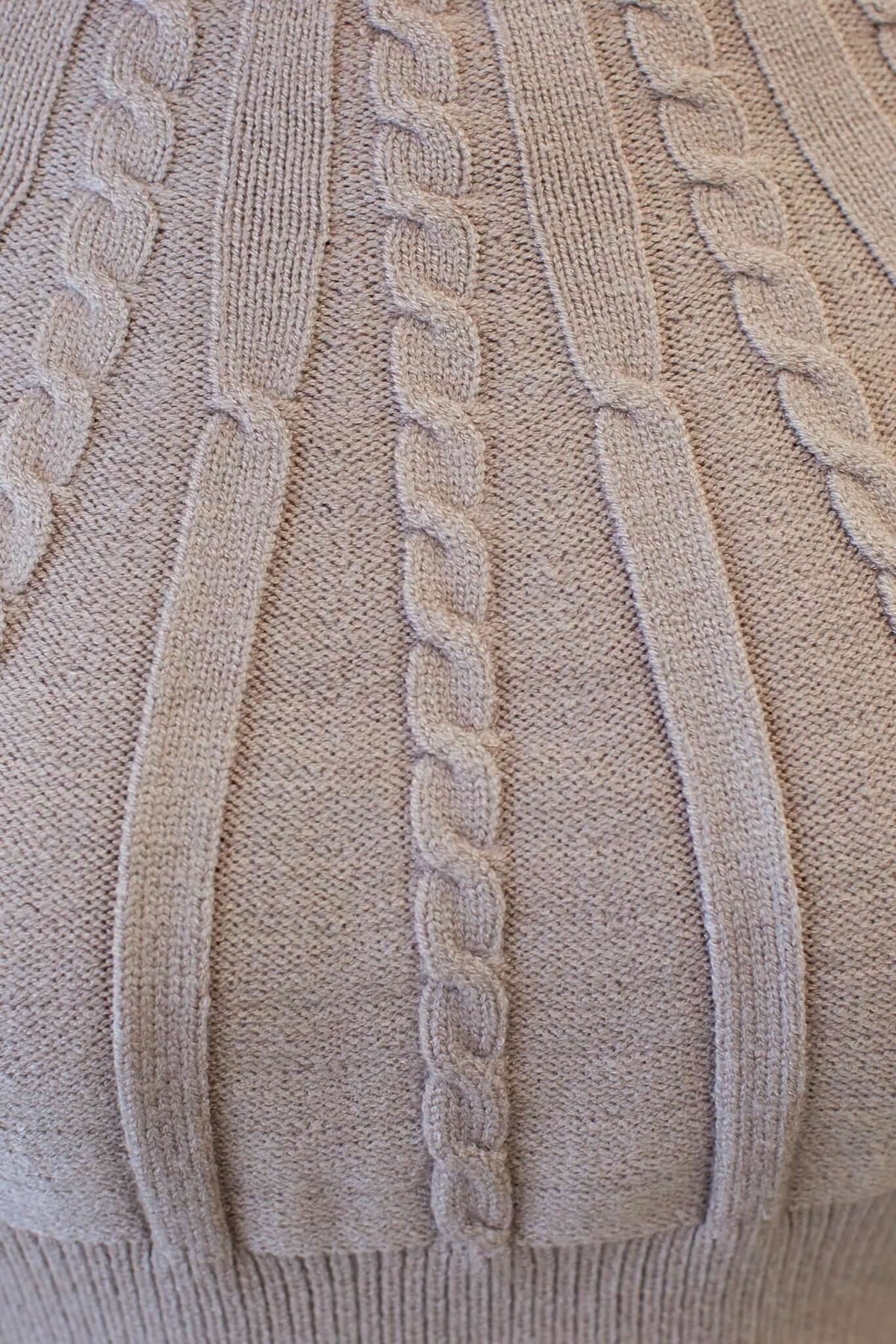 Close-up of the Alma Jumper showcasing a textured, cable knit design in soft beige color.