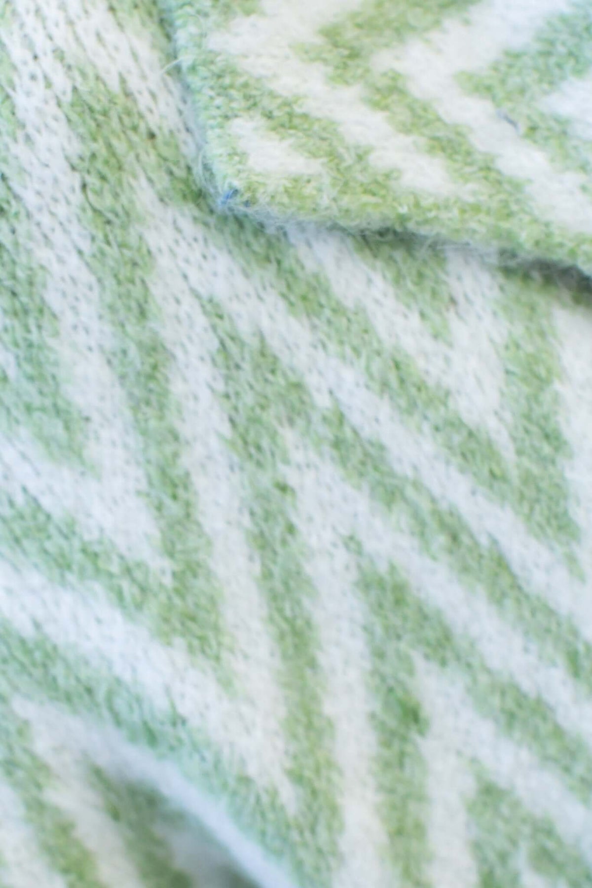 Close-up of Adabella Cardigan's green and white zigzag knit pattern showcasing soft texture and collar detail.