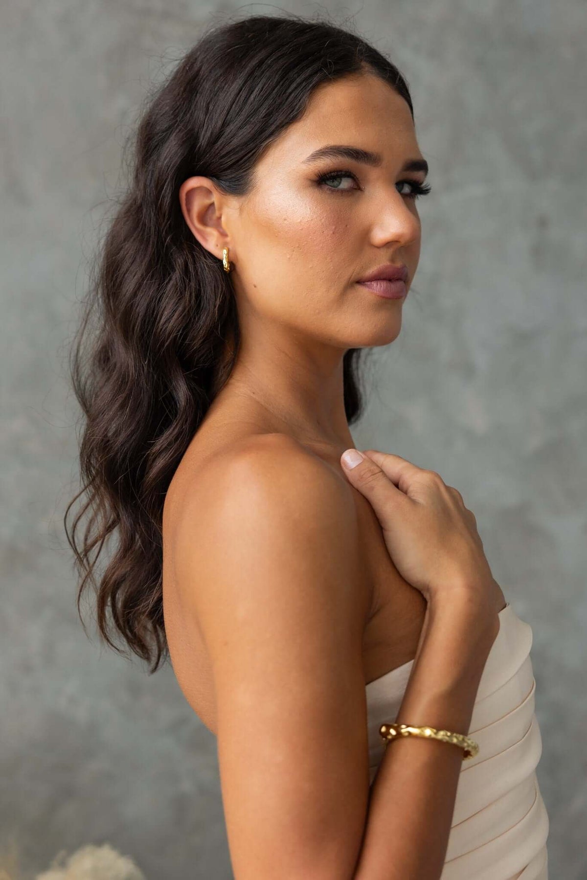 Model showcasing Laila Earrings, gold clasp earrings, elegantly styled with a neutral background.