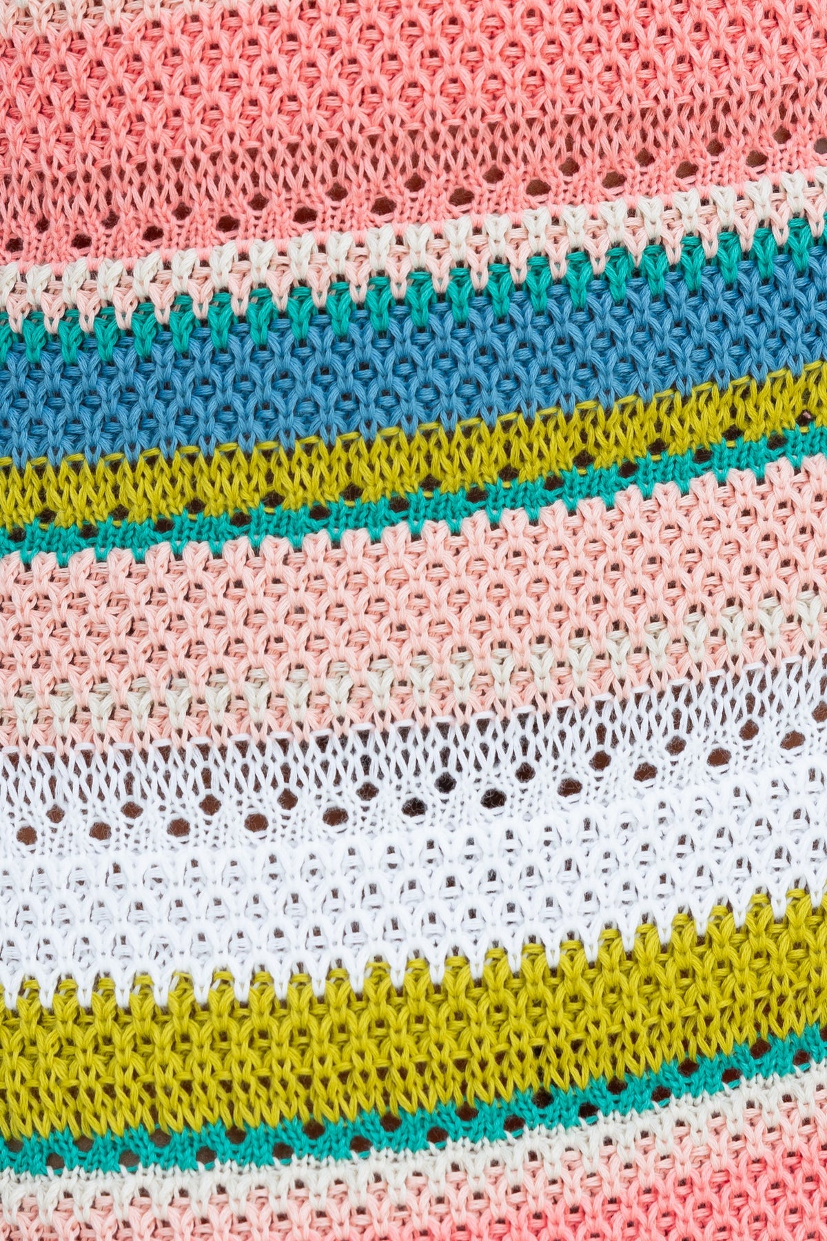 Close-up of colorful open weave crochet material in pink, blue, green, and yellow stripes, ideal for a maxi dress.