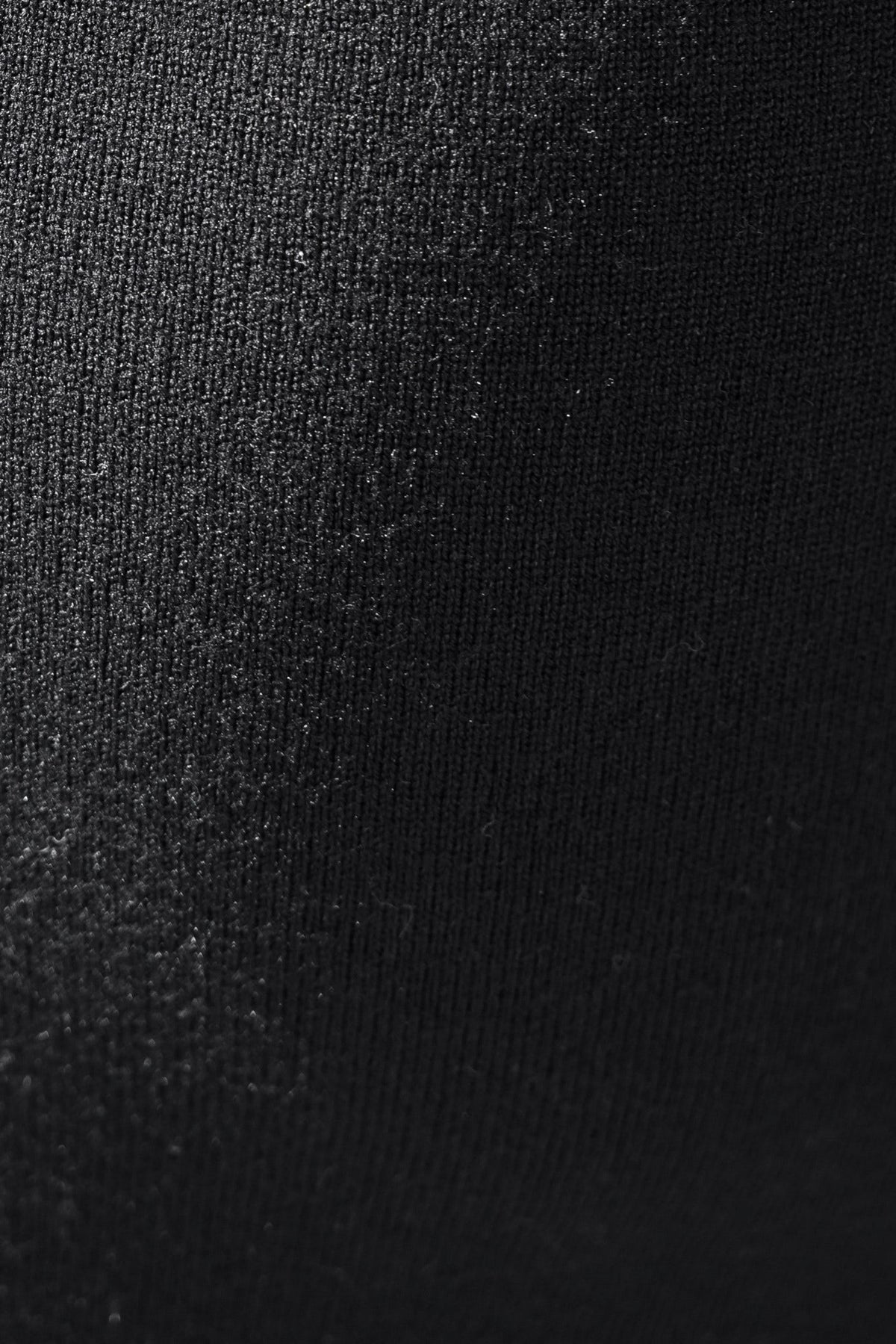 Close-up of black knit fabric texture used in the Tarnya Maxi Dress, showcasing its stretch material.