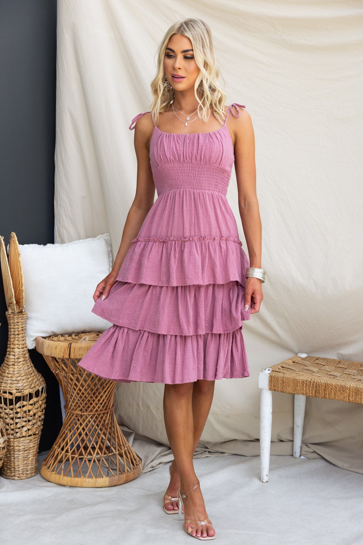 Clydie Midi Dress in pink with adjustable tie straps and tiered design, styled for a casual summer look.
