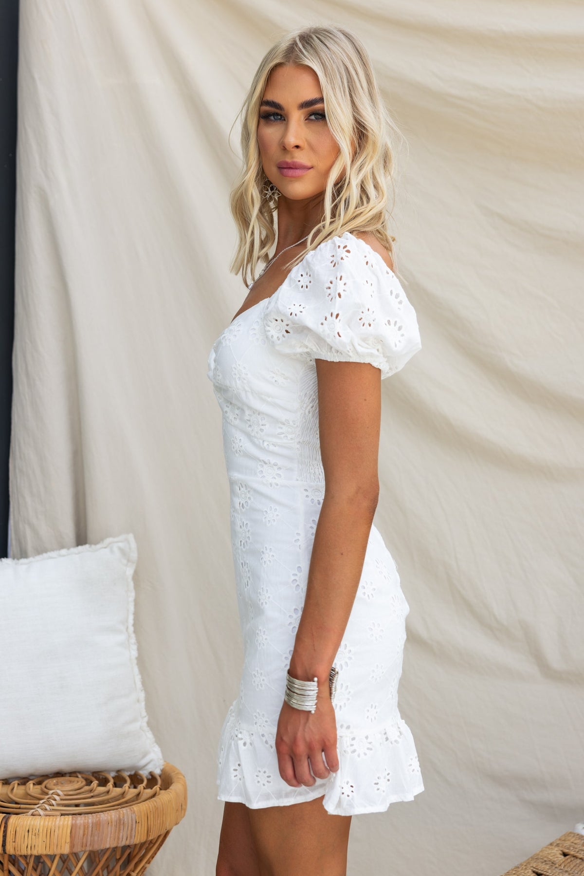Woman in white Elida Dress with puff sleeves and anglaise detail, styled against a neutral background.