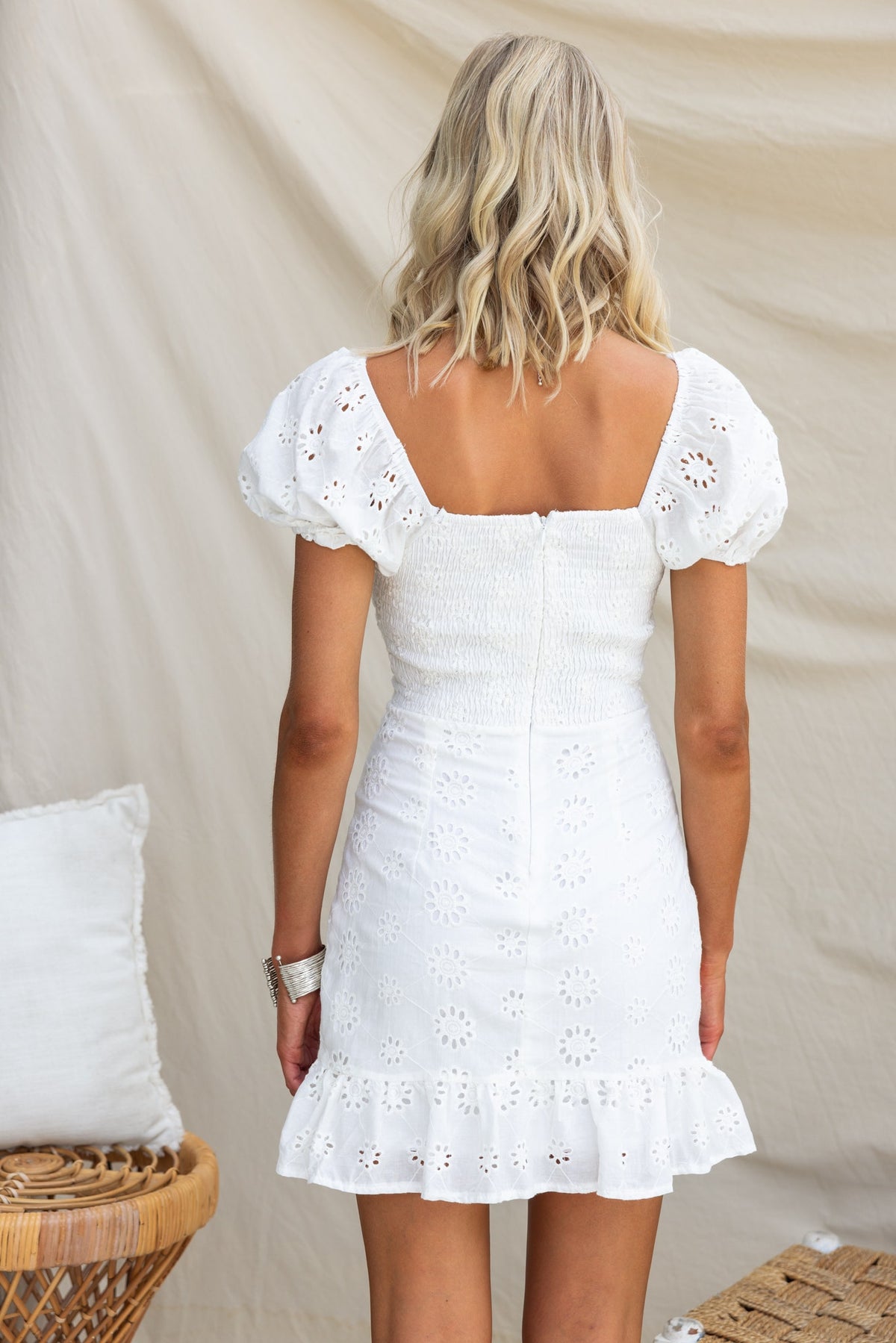 Back view of Elida Dress featuring elastic sleeves, twist detail, and Anglaise material in white.