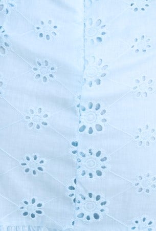 Close-up of light blue anglaise fabric with floral embroidery detail, perfect for the Elida Dress.