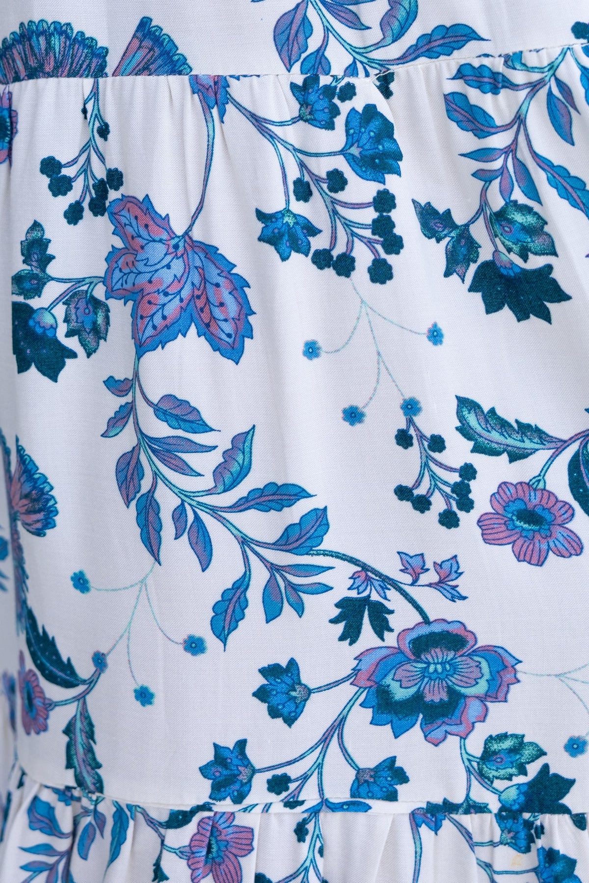 Close-up of floral print fabric on the Adios Maxi Dress featuring vibrant blue and purple leaves and flowers.