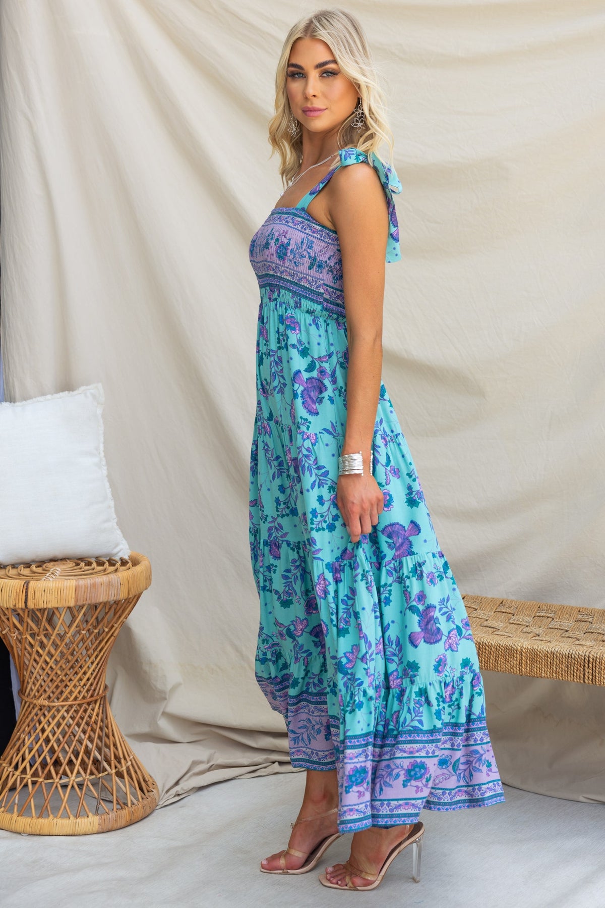 Stylish woman in a floral Adios Maxi Dress with adjustable straps, showcasing a light blue design and relaxed fit.