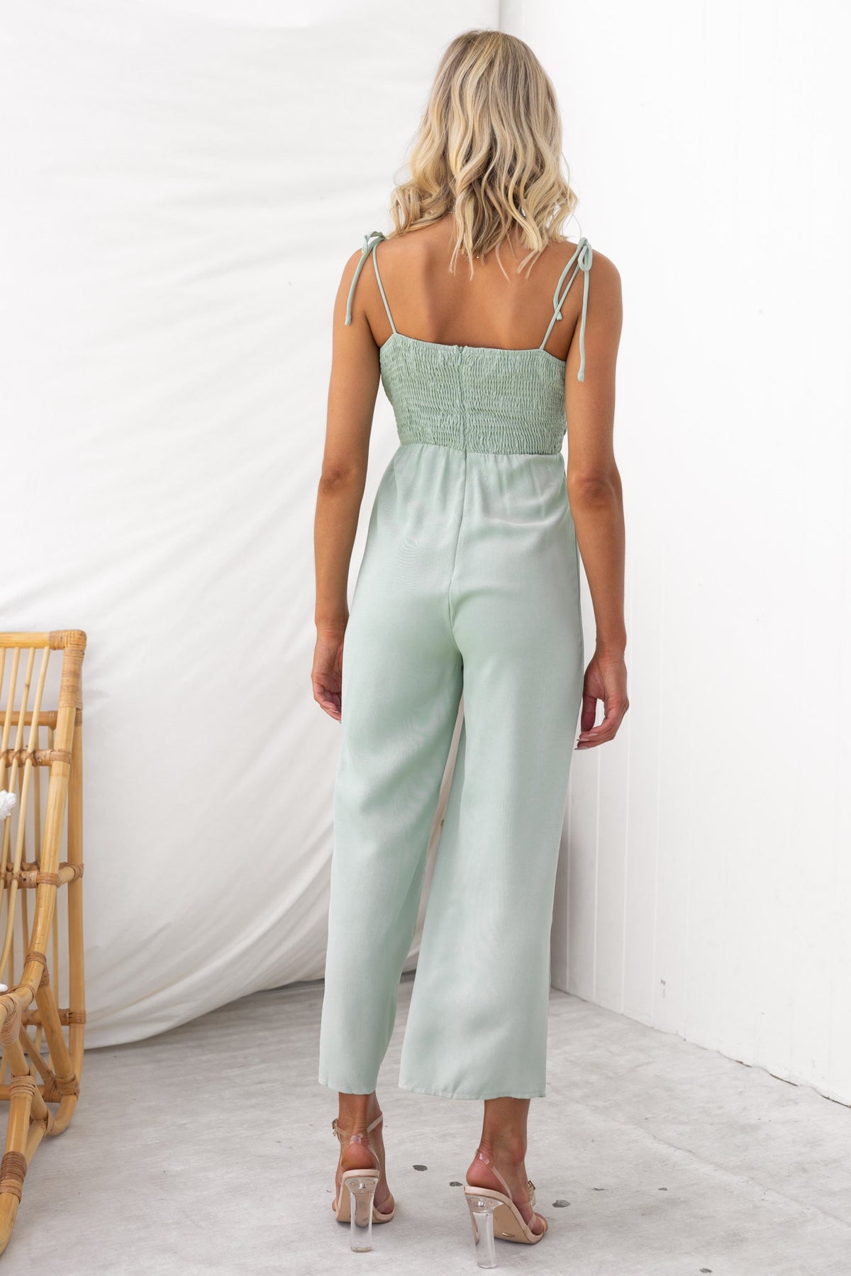 Back view of Nessa Jumpsuit featuring adjustable tie straps and a fitted bust in a soft mint green color.