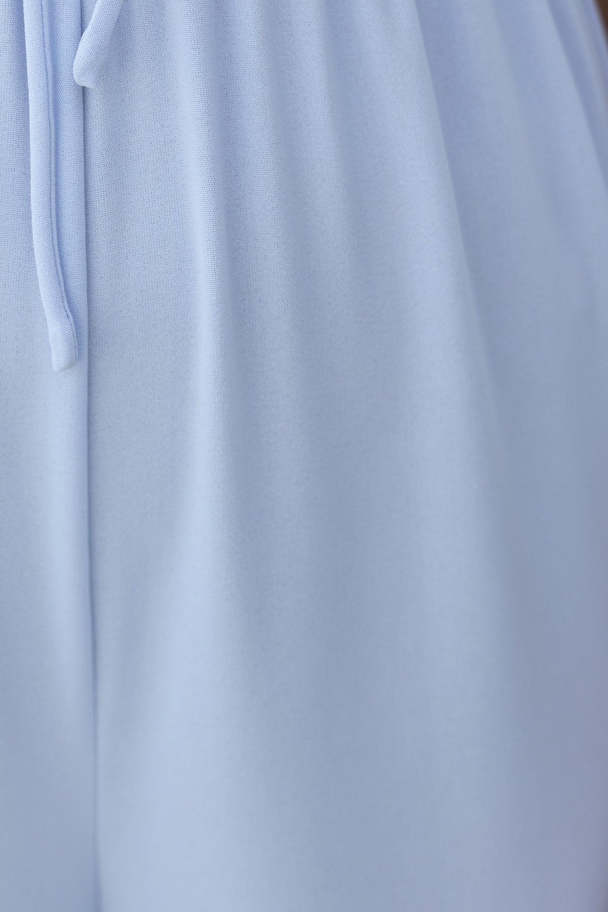 Close-up of Nessa Jumpsuit featuring soft blue fabric and adjustable tie straps for a stylish fit.