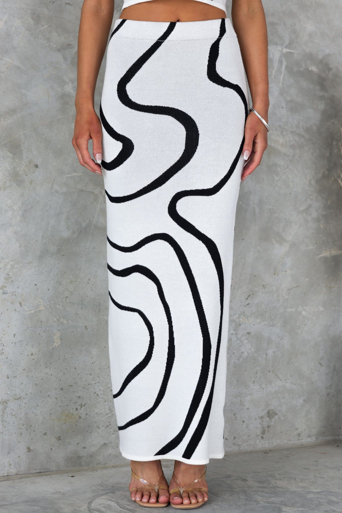 Model wearing Undisturbed Maxi Skirt with black and white abstract pattern, showcasing its mid-high waist and knit material.
