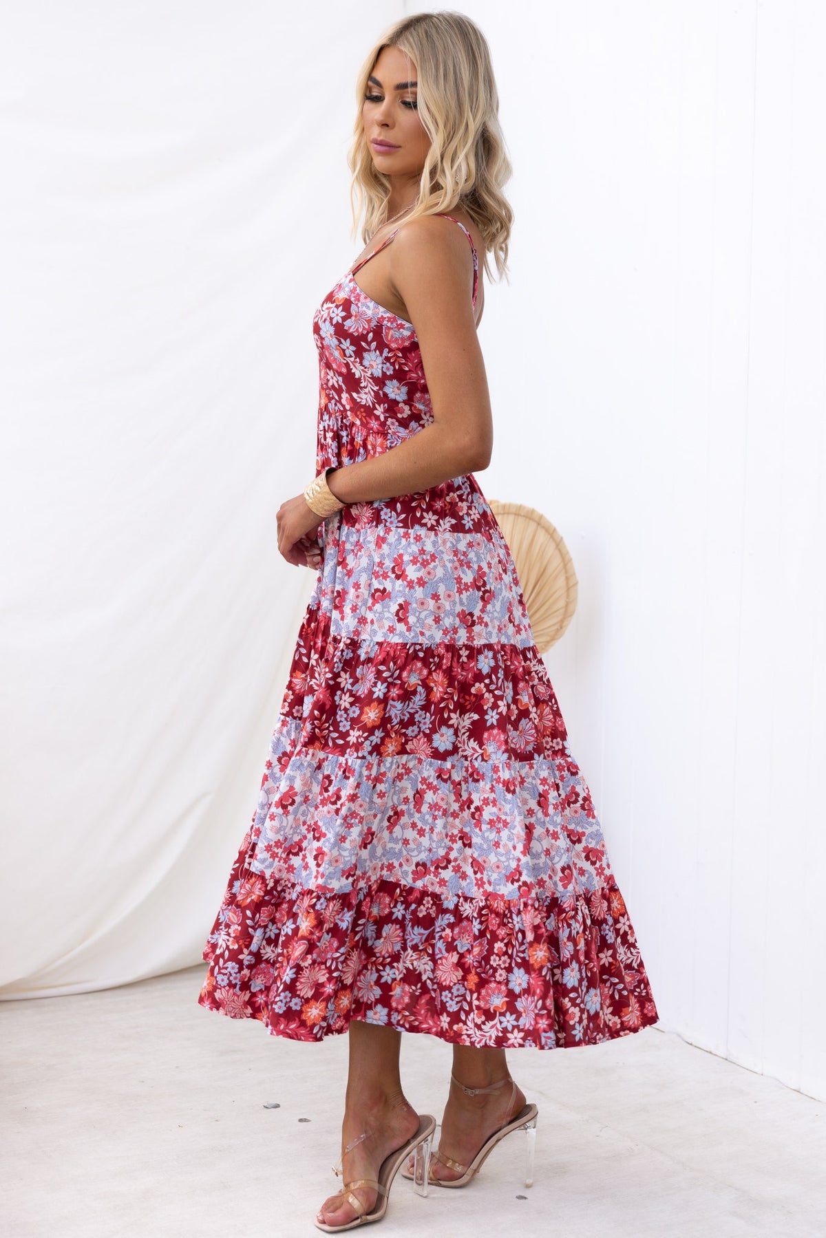 Side view of a woman in a floral Aryana Midi Dress featuring adjustable straps and tiered design.