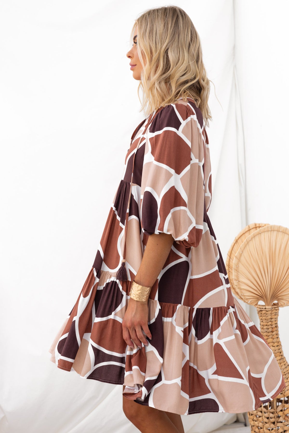 Side view of a model in the Alisti dress, featuring a colorful geometric pattern and a relaxed fit.