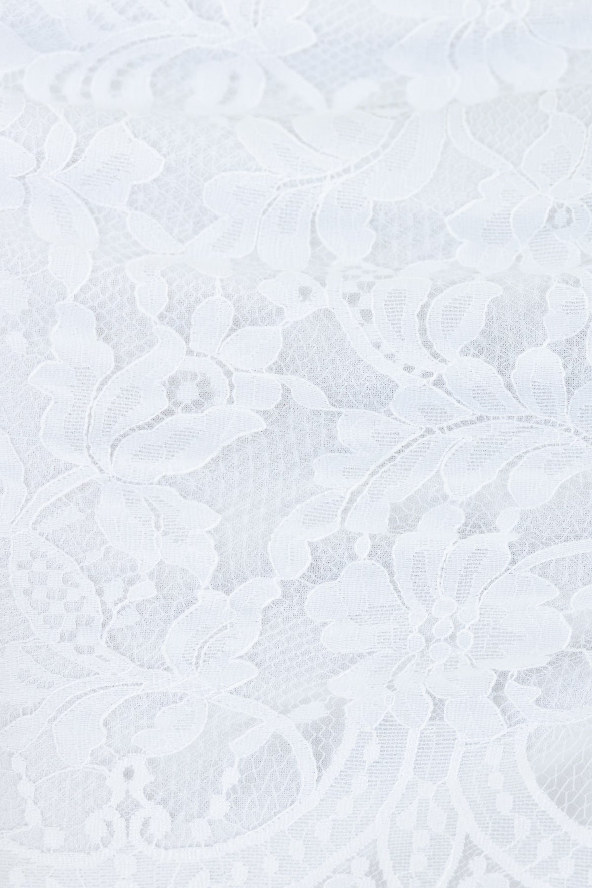 Elegant white lace fabric pattern, perfect for adding a delicate touch to garments or accessories.