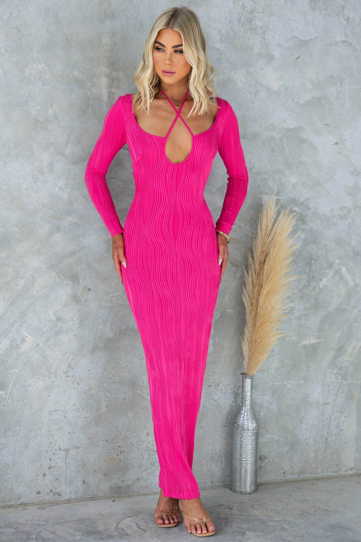 Pamalo Maxi Dress in vibrant pink, featuring a cut-out bust design and long sleeves, stylish and form-fitting.