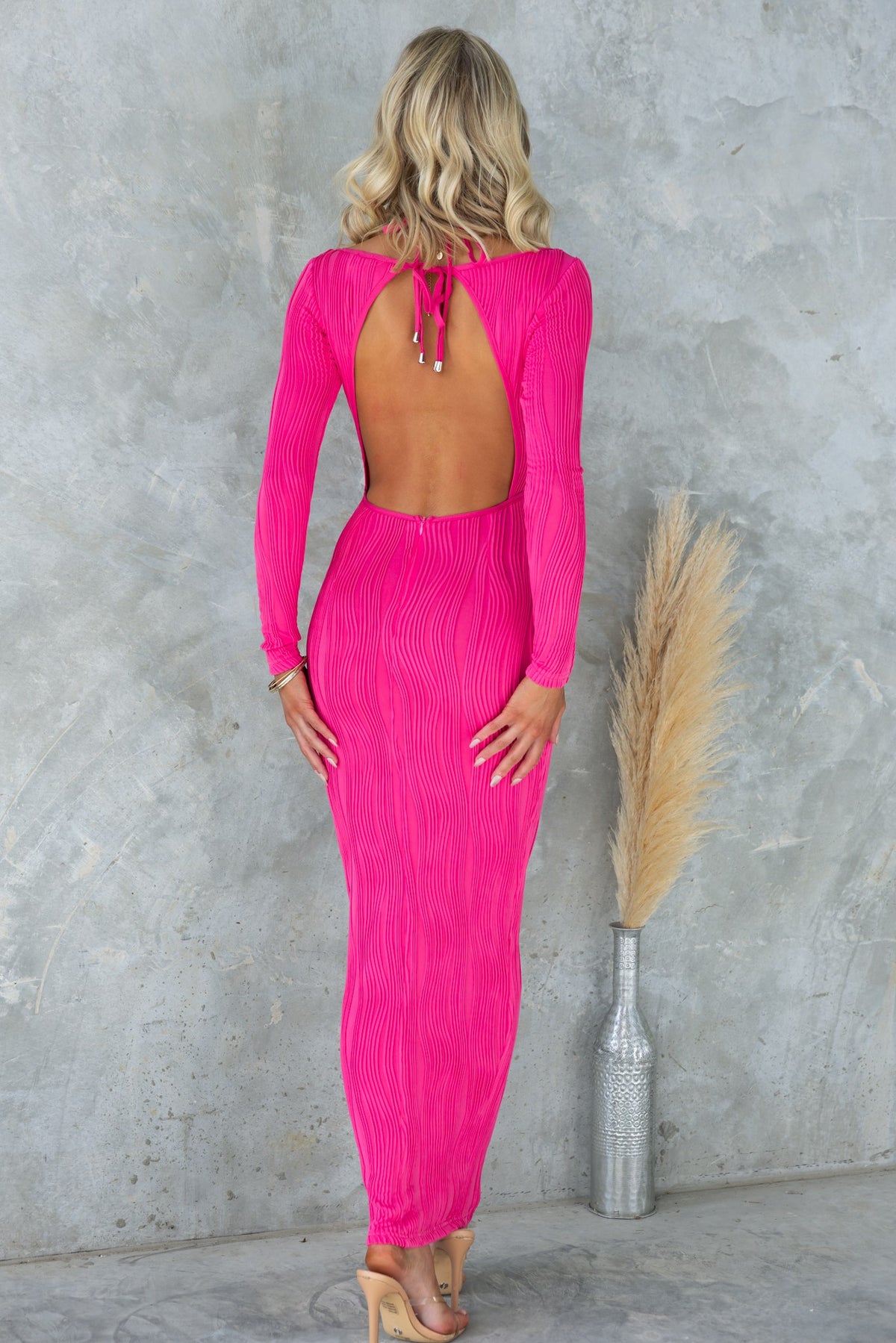 Pamalo Maxi Dress: Bright pink backless maxi dress with textured material and tie detailing, perfect for stylish summer outings.