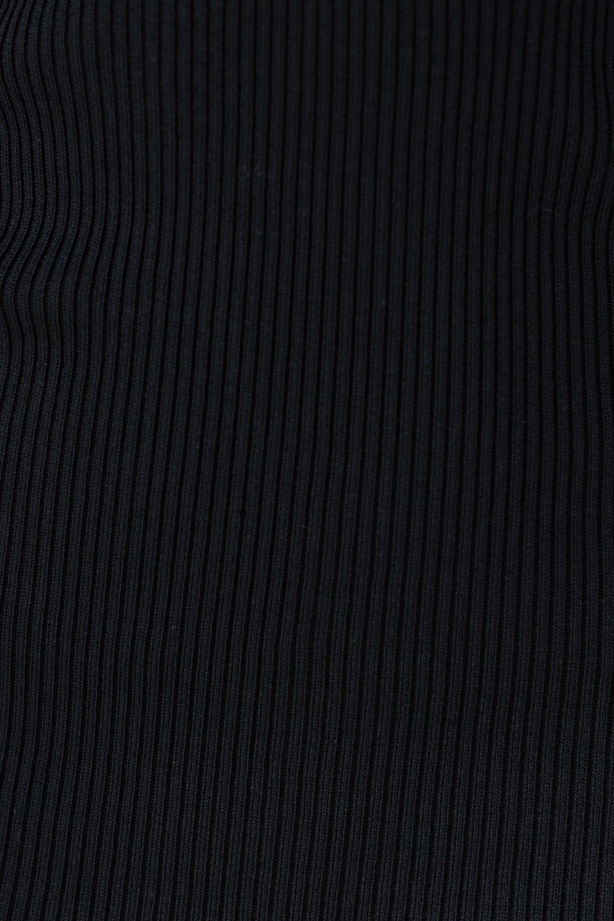 Close-up of the ribbed black fabric of the Kimber Midi Dress, showcasing its stretch and texture.