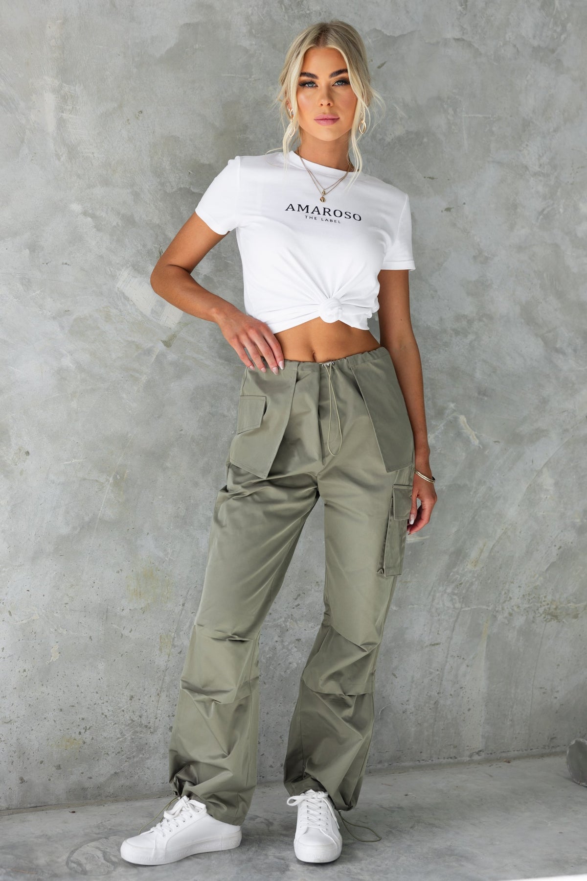 Model wearing Omar Cargo Pants, stylish high-mid waist with drawstring, paired with a white cropped t-shirt.