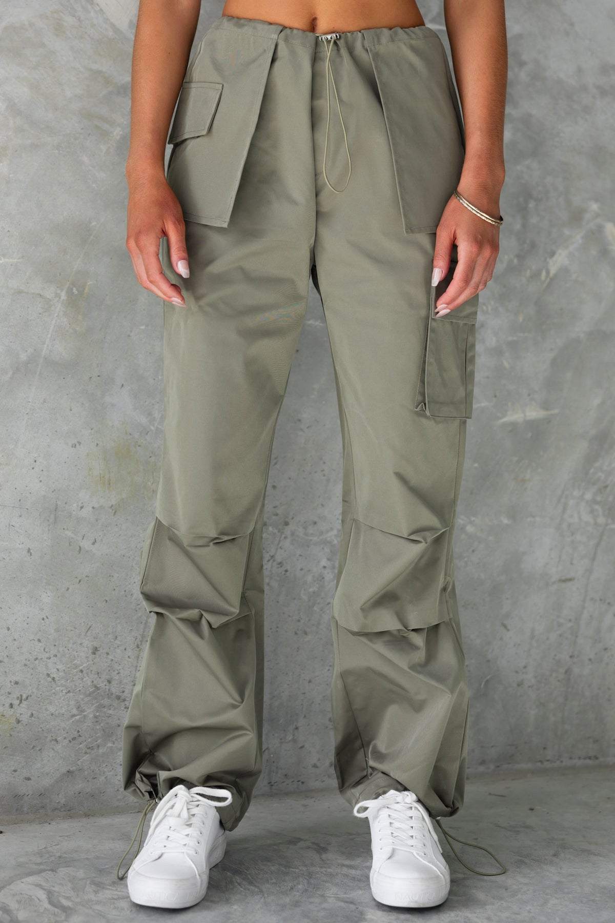 Omar Cargo Pants in olive green with drawstring waist and pockets, styled with white sneakers.