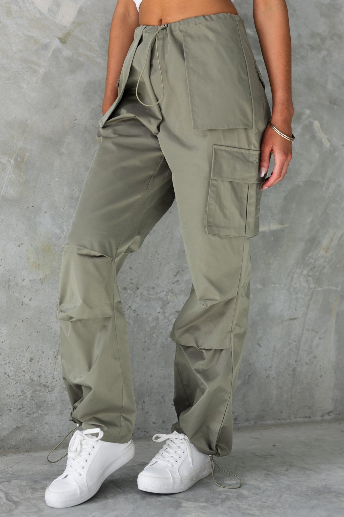 Omar Cargo Pants in olive green with drawstrings, wide legs, and pockets, styled with white sneakers.