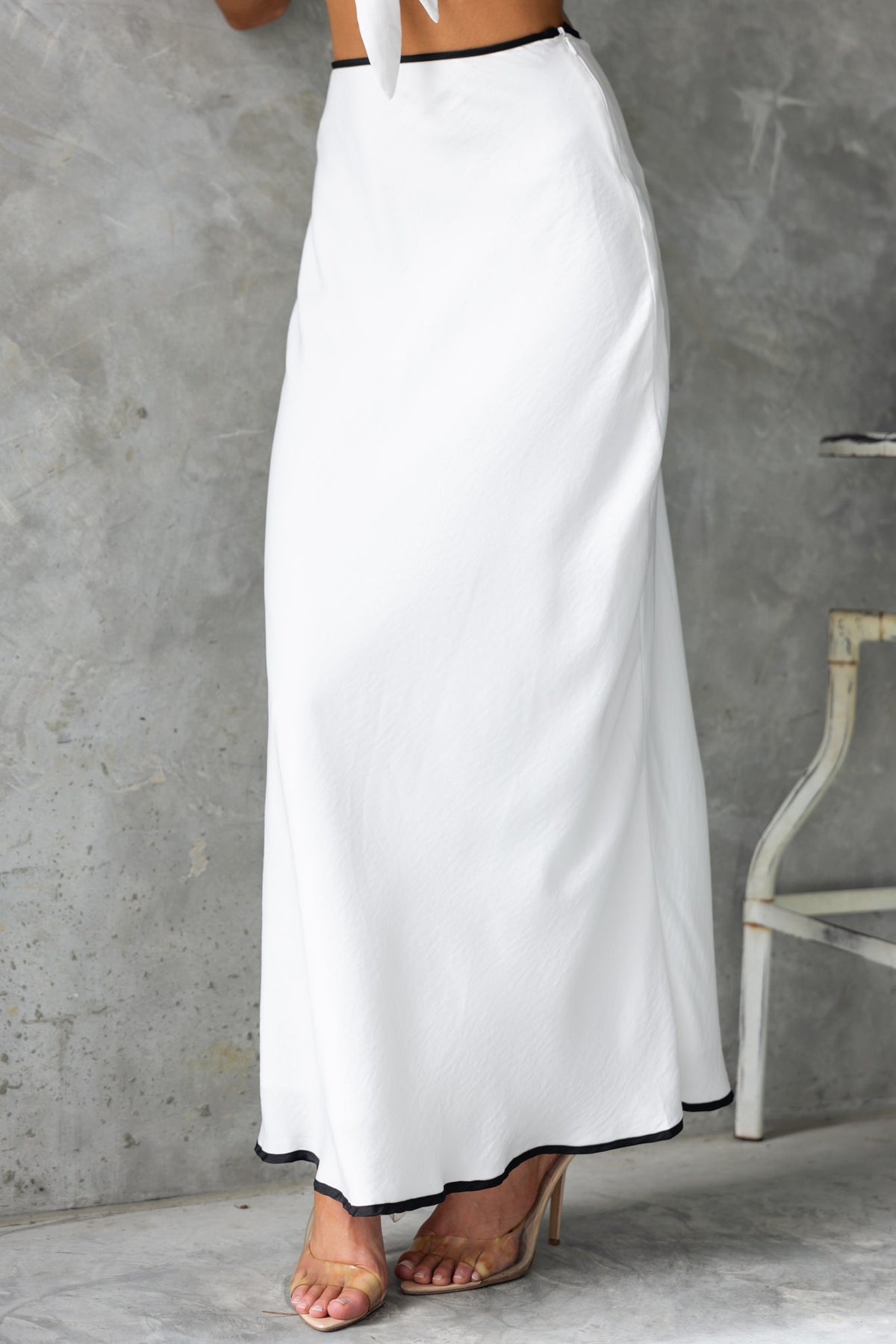 Virage Maxi Skirt in white with black trim, showcasing mid-high waist fit, perfect for elegant occasions.