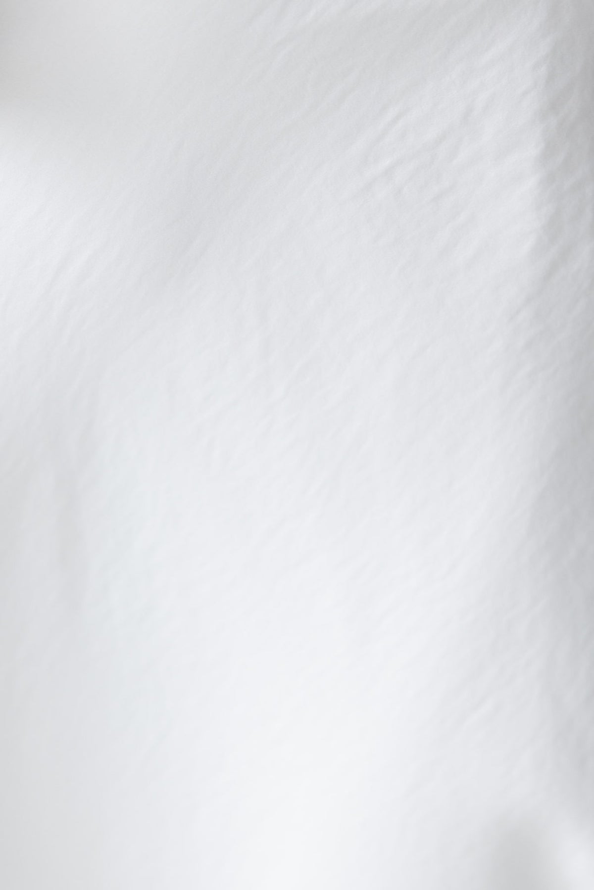 Close-up of soft, textured fabric in white, ideal for maxi skirts and elegant clothing.