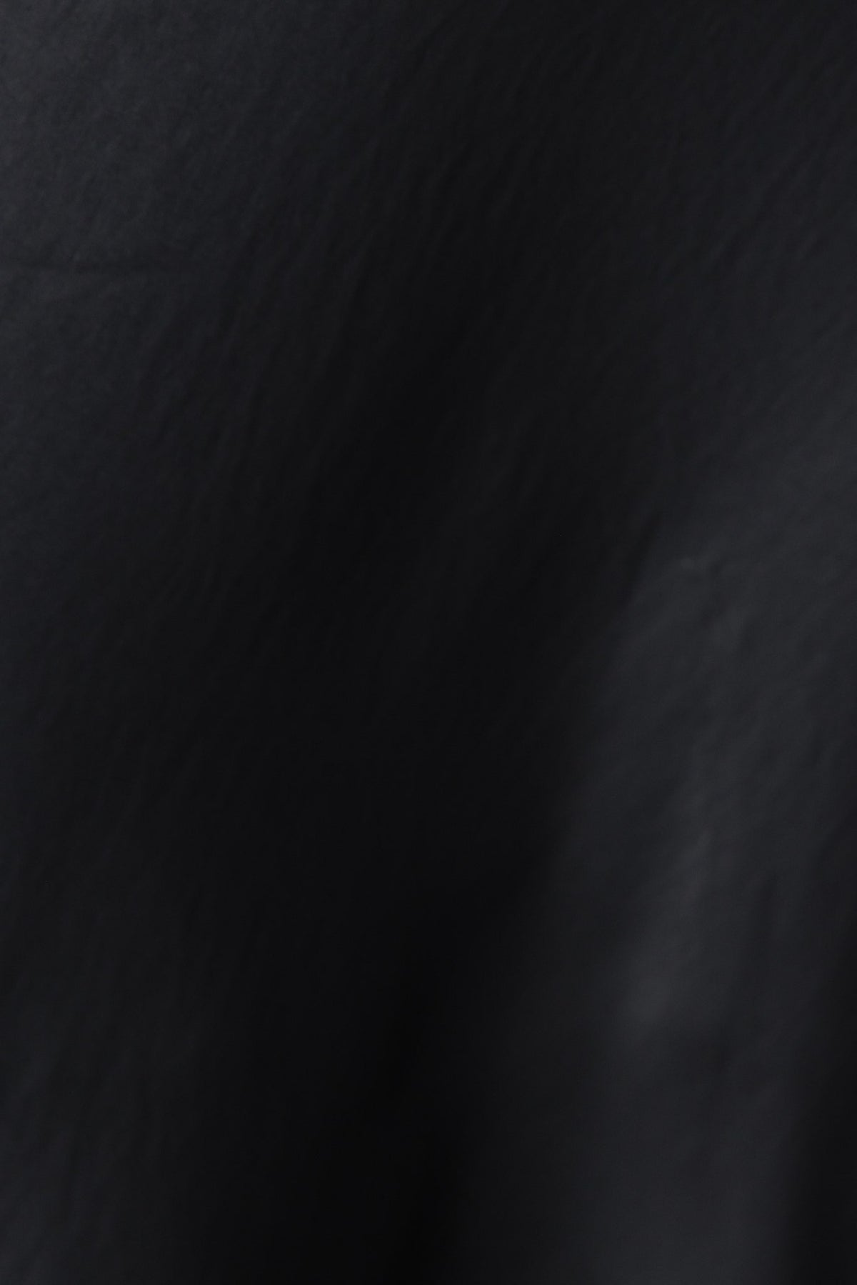Close-up of black fabric texture of the Virage Top, showcasing smooth material ideal for stylish summer wear.