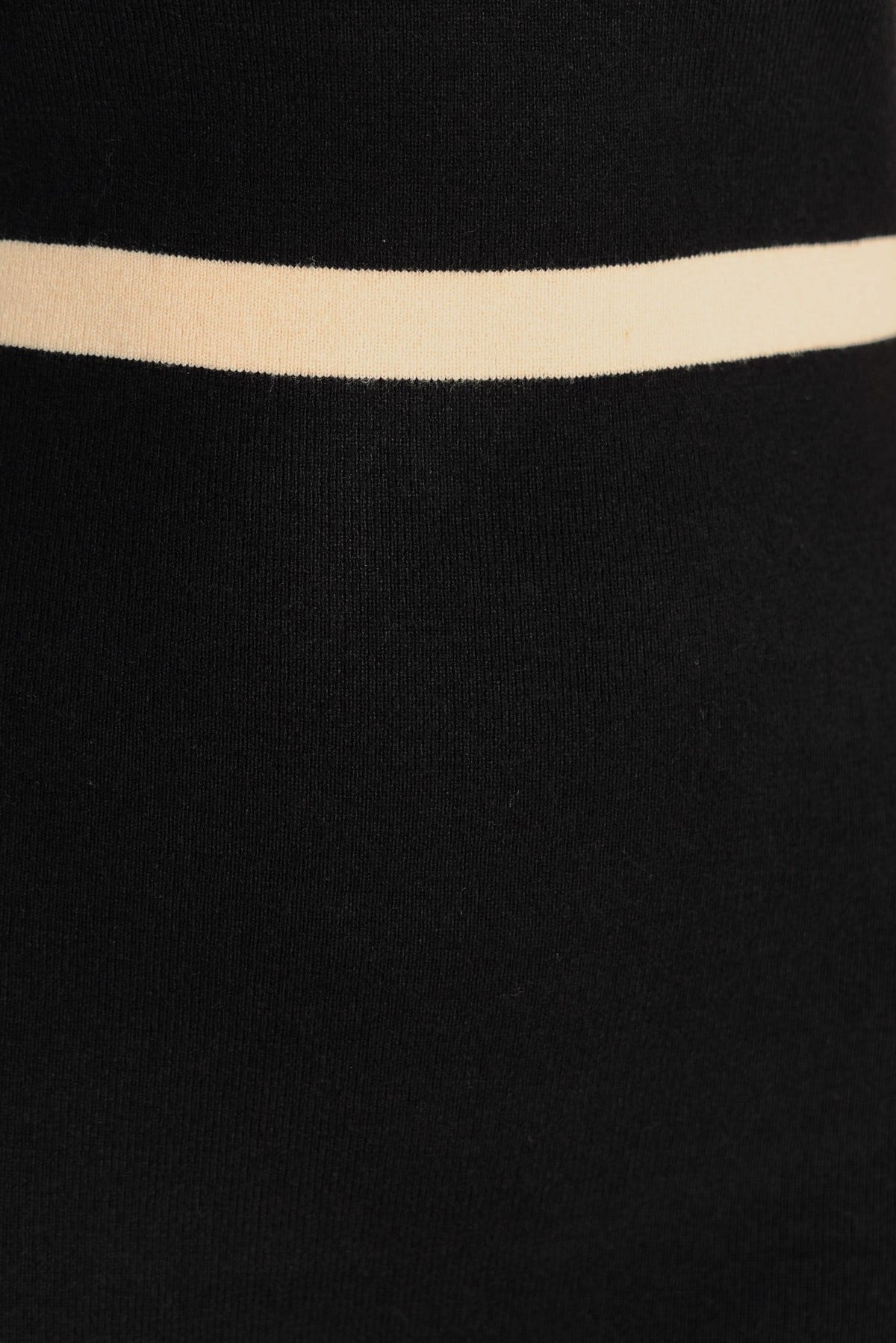 Close-up of black ribbed knit fabric featuring a light beige horizontal stripe.