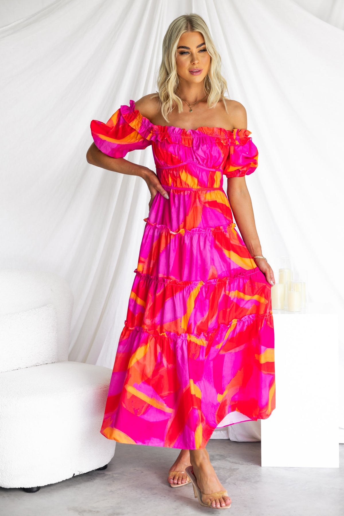 Model wearing a vibrant pink off-shoulder Archer Maxi Dress, featuring tiered layers and a relaxed fit.
