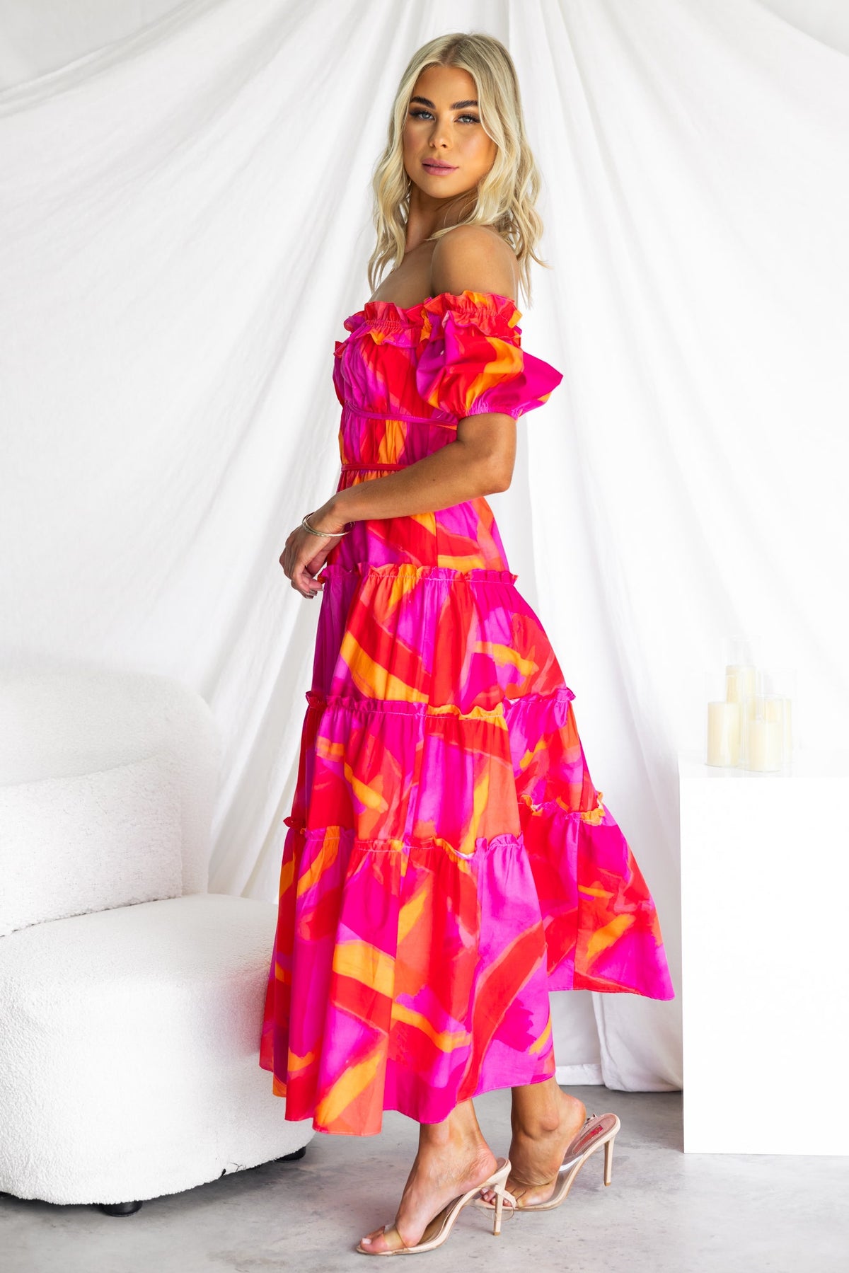 Model wearing an Archer Maxi Dress, featuring an off-shoulder neckline and vibrant pink pattern.