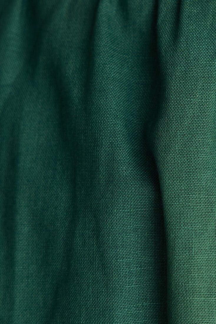 Close-up of the green linen fabric showcasing texture and color variance for the Binita Maxi Dress.
