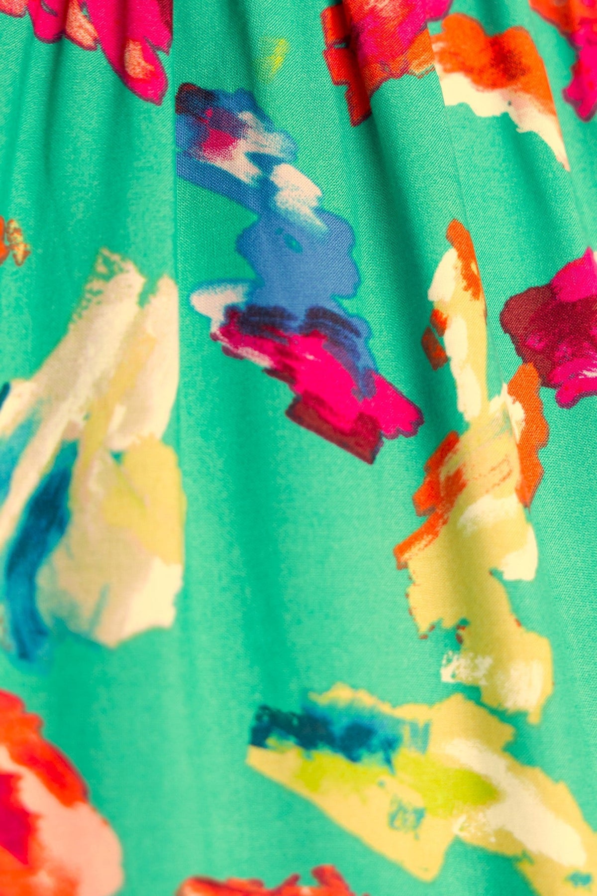 Close-up of colorful abstract print on Charmayne midi dress in vibrant teal and pink hues.