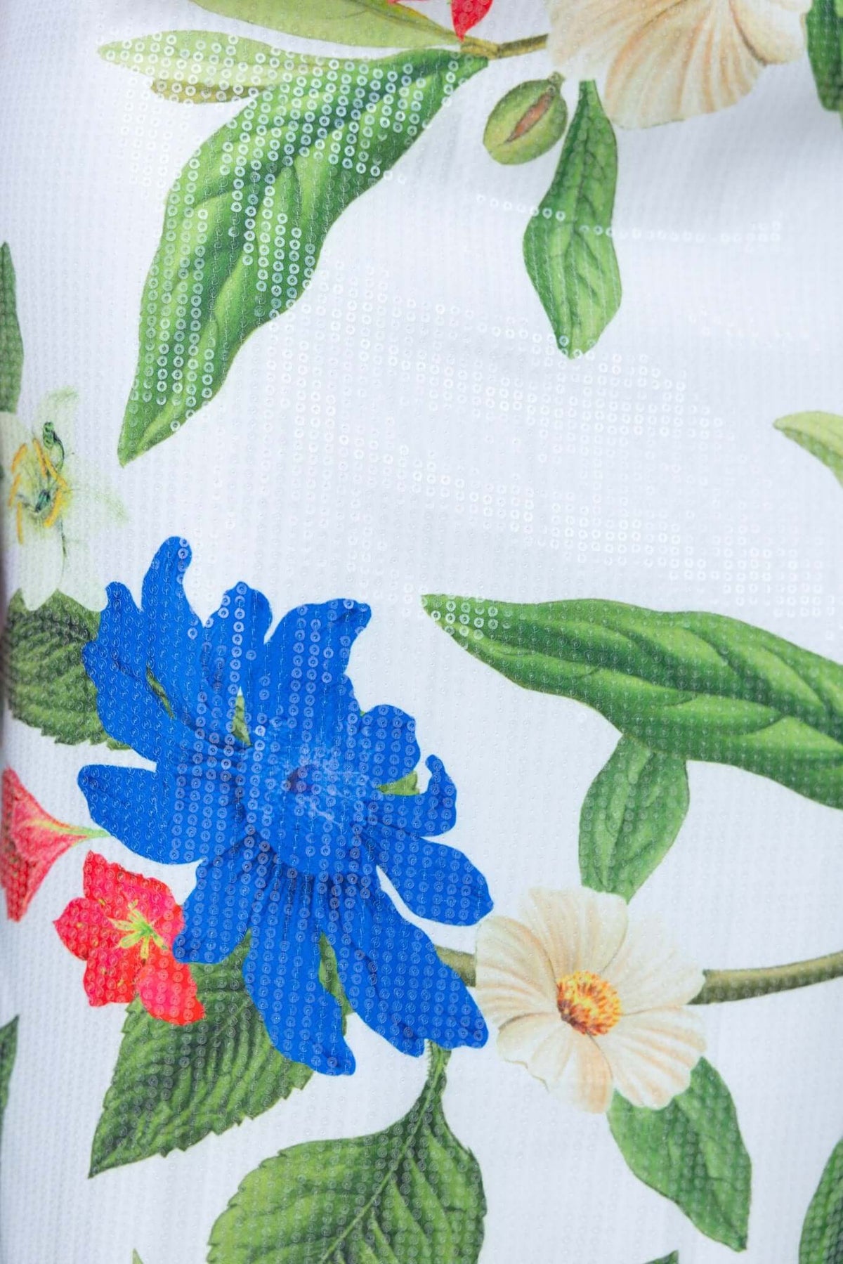 Close-up of floral fabric with sequins featuring blue and red flowers on a white background for Frutta Maxi Dress.